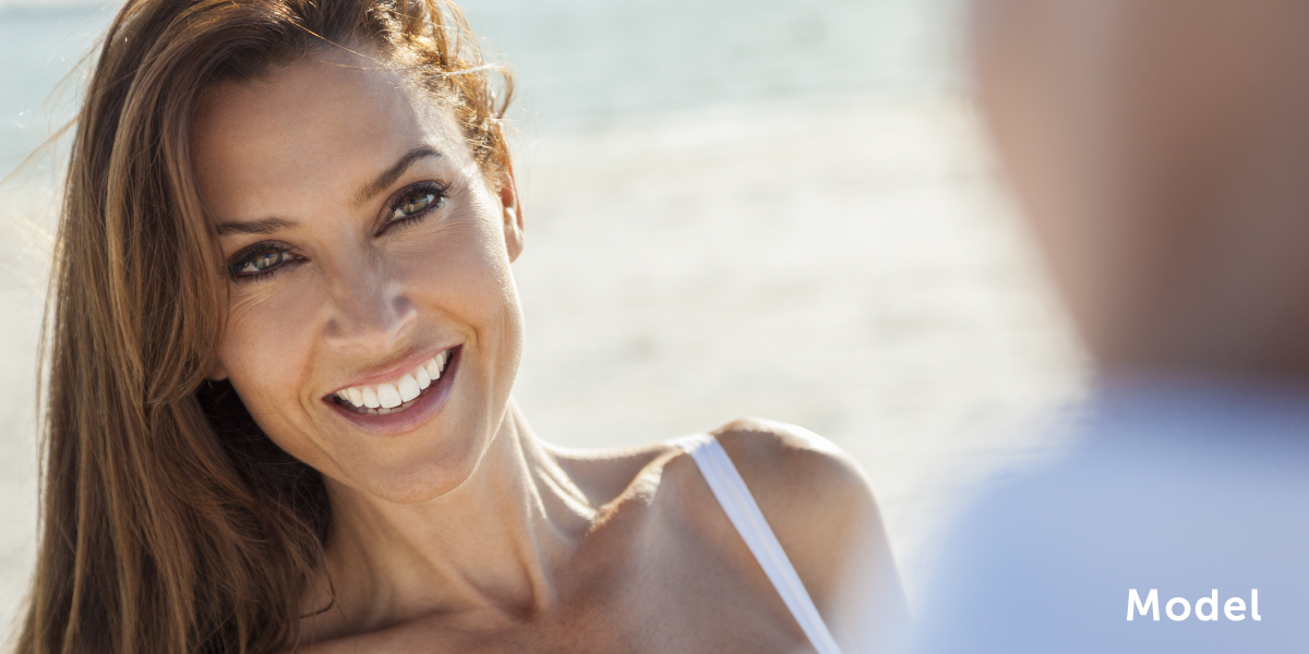 Model on beach smiling chattanooga periodontics dental implants
